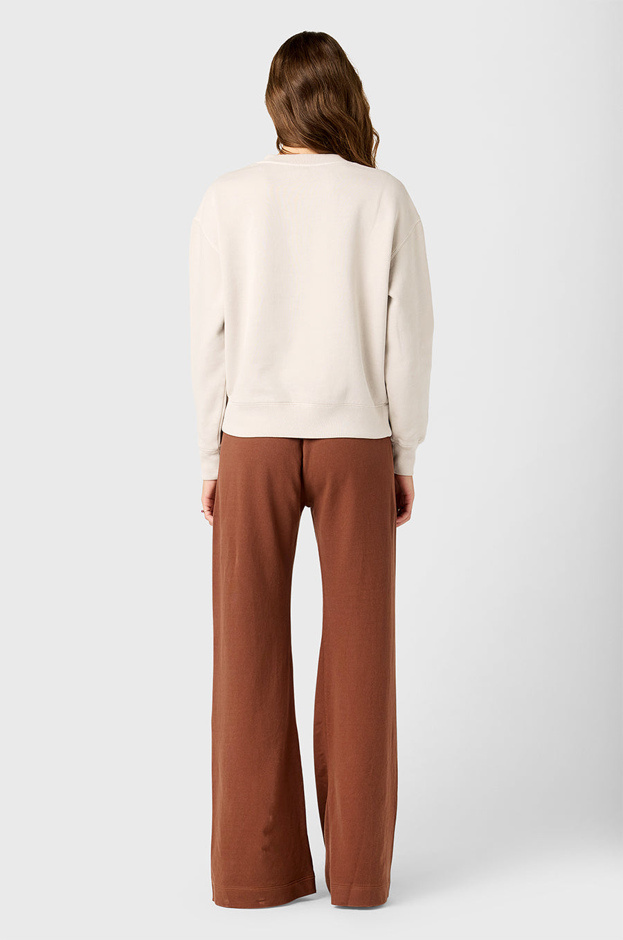 Model wearing The Lady & The Sailor's Tomboy Sweatshirt in Washed Ecru with Lady Embroidery and Wide Leg Pant in Chestnut Cotton Twill.