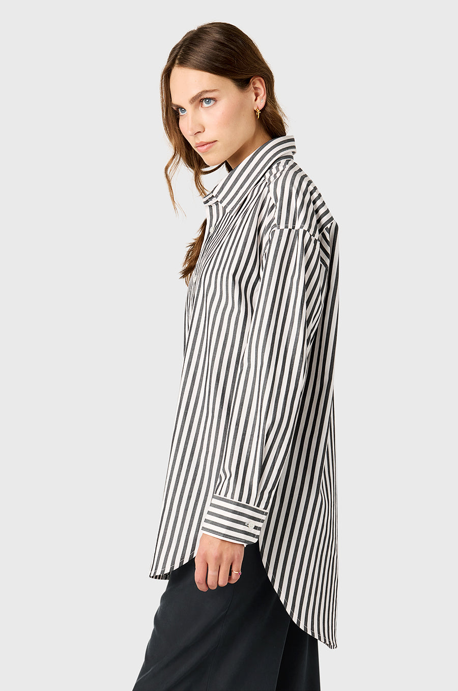 Model wearing The Lady & The Sailor Curved Hem Button up in Black/Ivory Stripe and Silky Wide Leg Pant in Washed Black.