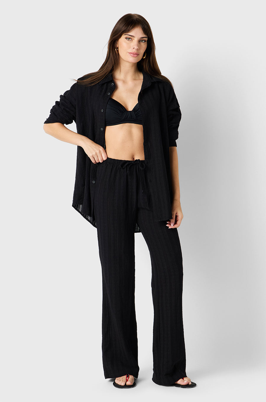 Brunette model wearing the lady & the sailor Beach Pant in Black Beach Stripe