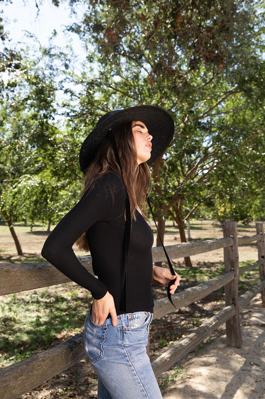 Brunette model wearing the lady & the sailor Long Sleeve Scoopneck Tee in Black Thermal.