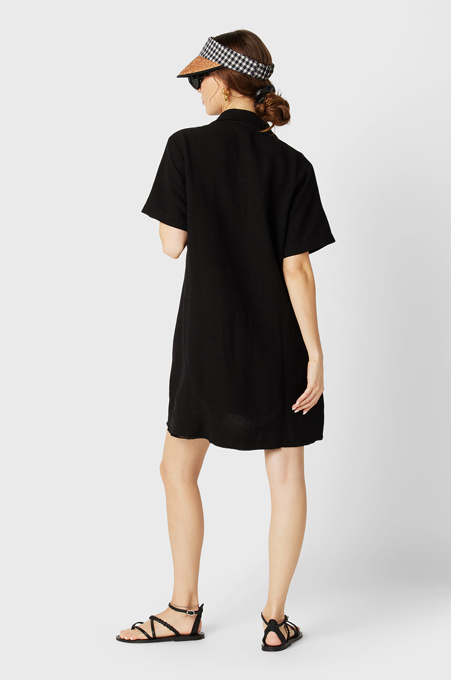 Brunette Model wearing the lady & the sailor the Button Up Mini Dress in Black.