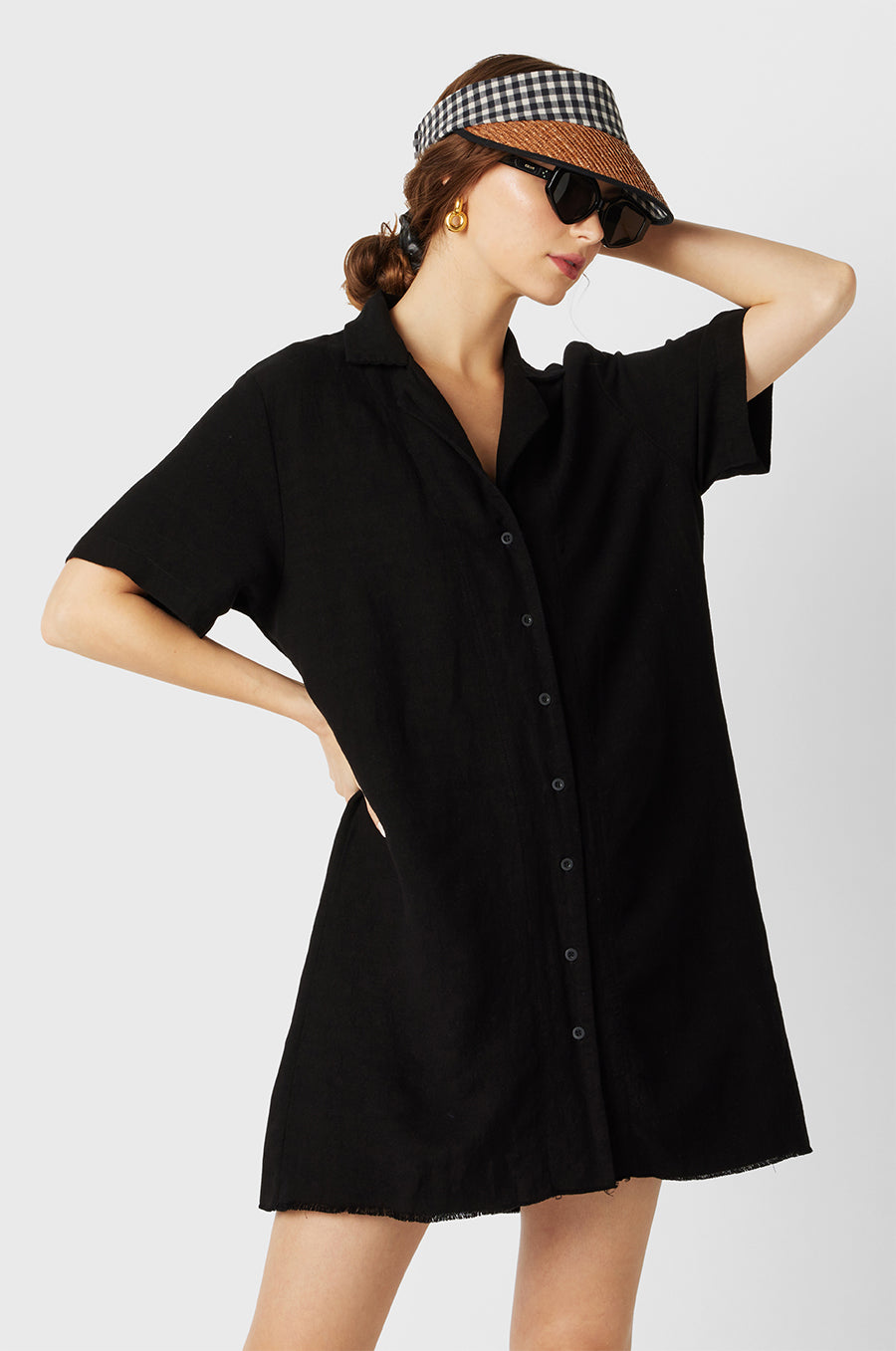 Brunette Model wearing the lady & the sailor the Button Up Mini Dress in Black.