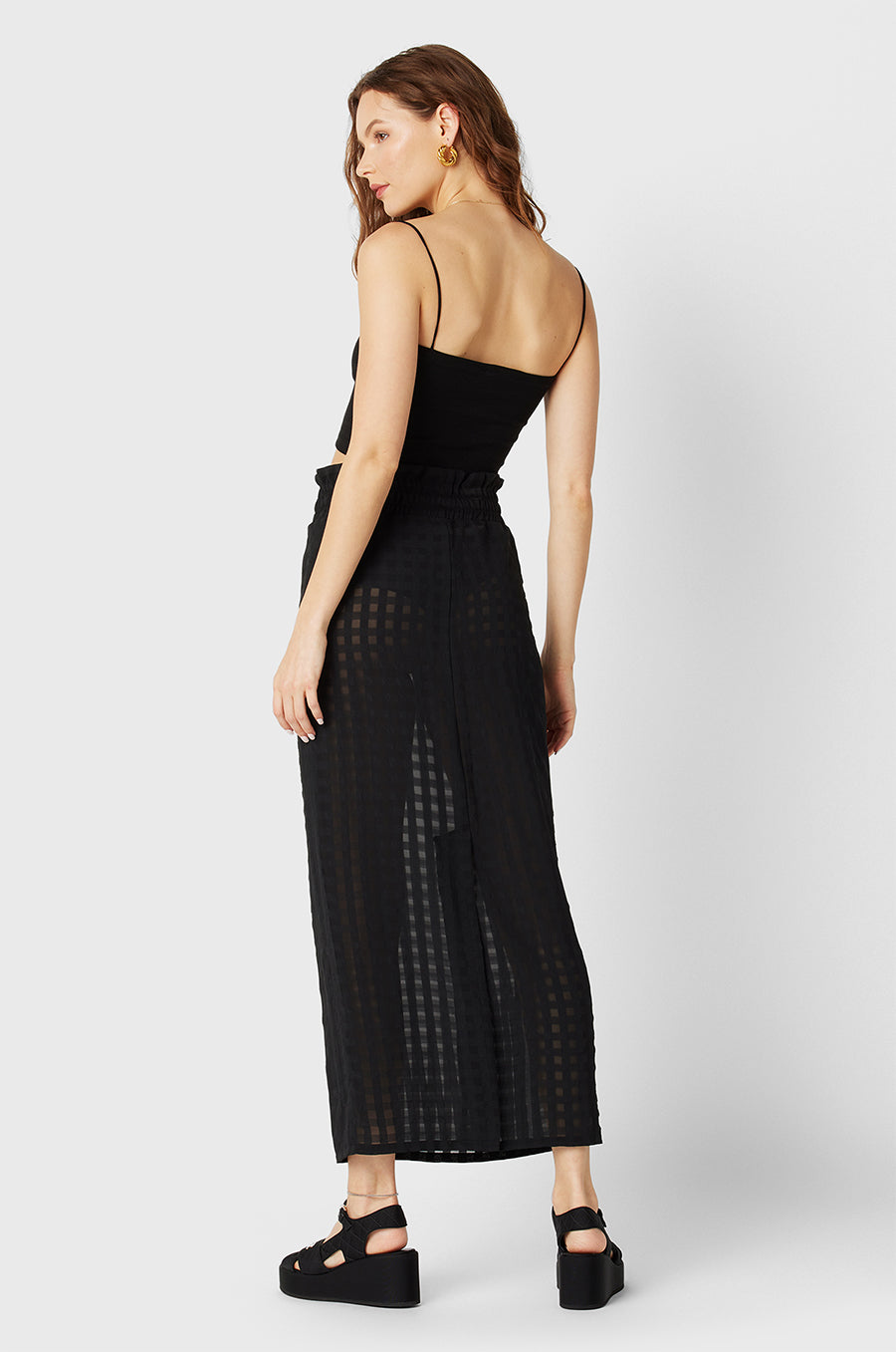 Model wearing the lady & the sailor Smocked Midi Skirt in Black Gingham.