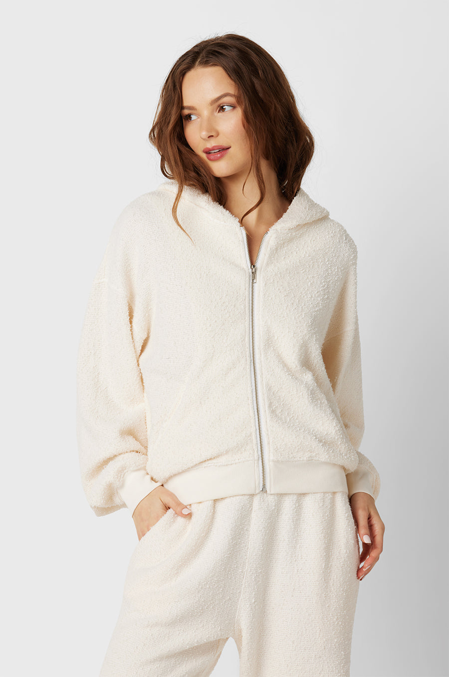 Brunette Model wearing the lady & the sailor the Zip Up Hoodie in Vanilla Boucle.