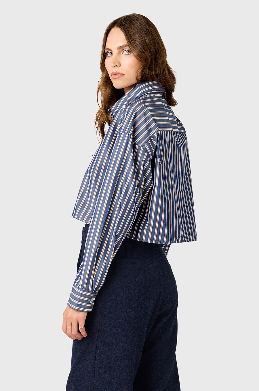 Model wearing the lady & the sailor Cropped Boxy Button Up in Indigo Stripe.