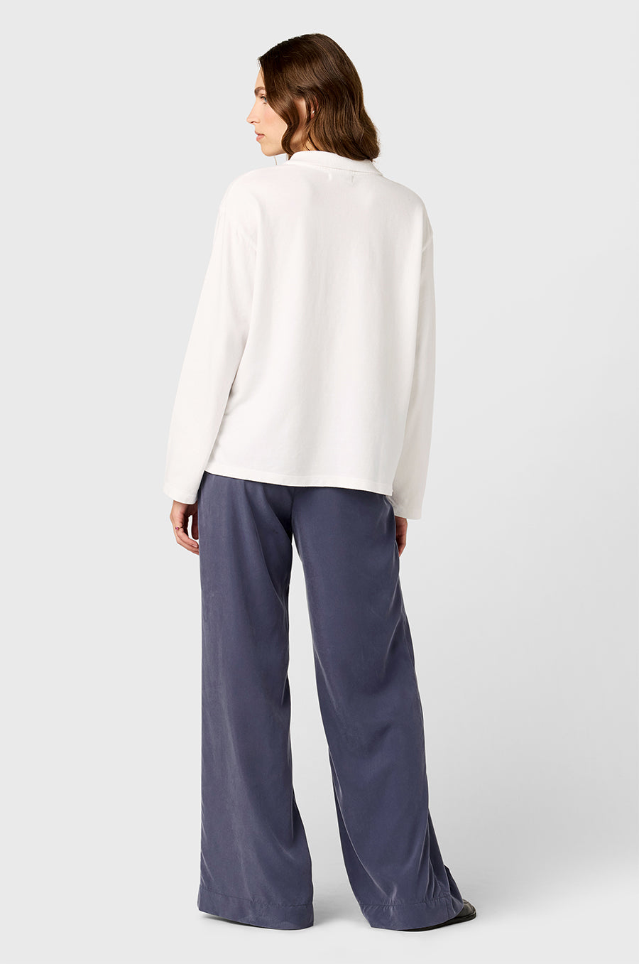 Model wearing the lady & the sailor BF Polo in White Cotton Twill and Silky Wide Leg Pants in Washed Steel.