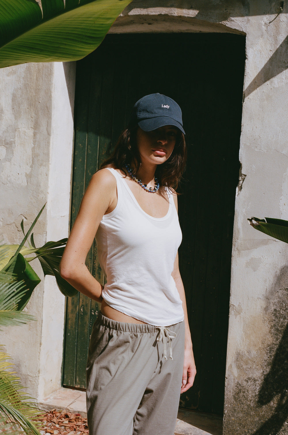 lady classic cap in navy/white styled with the feather scoop tank in white sheer cotton and the relaxed sweatpant in taupe jersey - the lady & the sailor