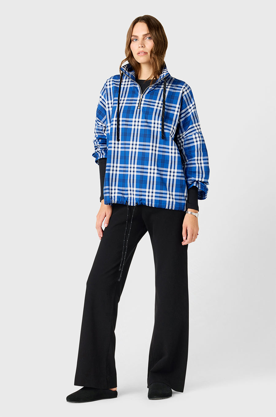Model wearing The Lady & The Sailor Anorak in Royal Blue Plaid - a quarter zip anorak with a tall collar and relaxed fit, the Long Sleeve Classic Tee in Black Classic Rib, and the Pocket Straight Leg Pant in Black Cotton Twill.