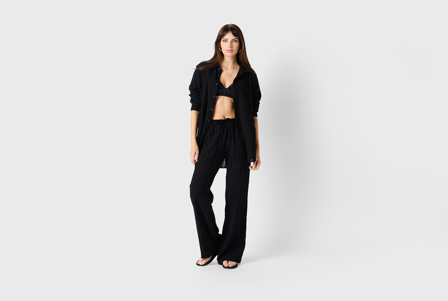 Brunette model wearing the lady & the sailor Beach Pant in Black Beach Stripe