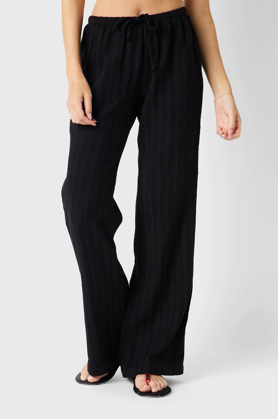 Brunette model wearing the lady & the sailor Beach Pant in Black Beach Stripe