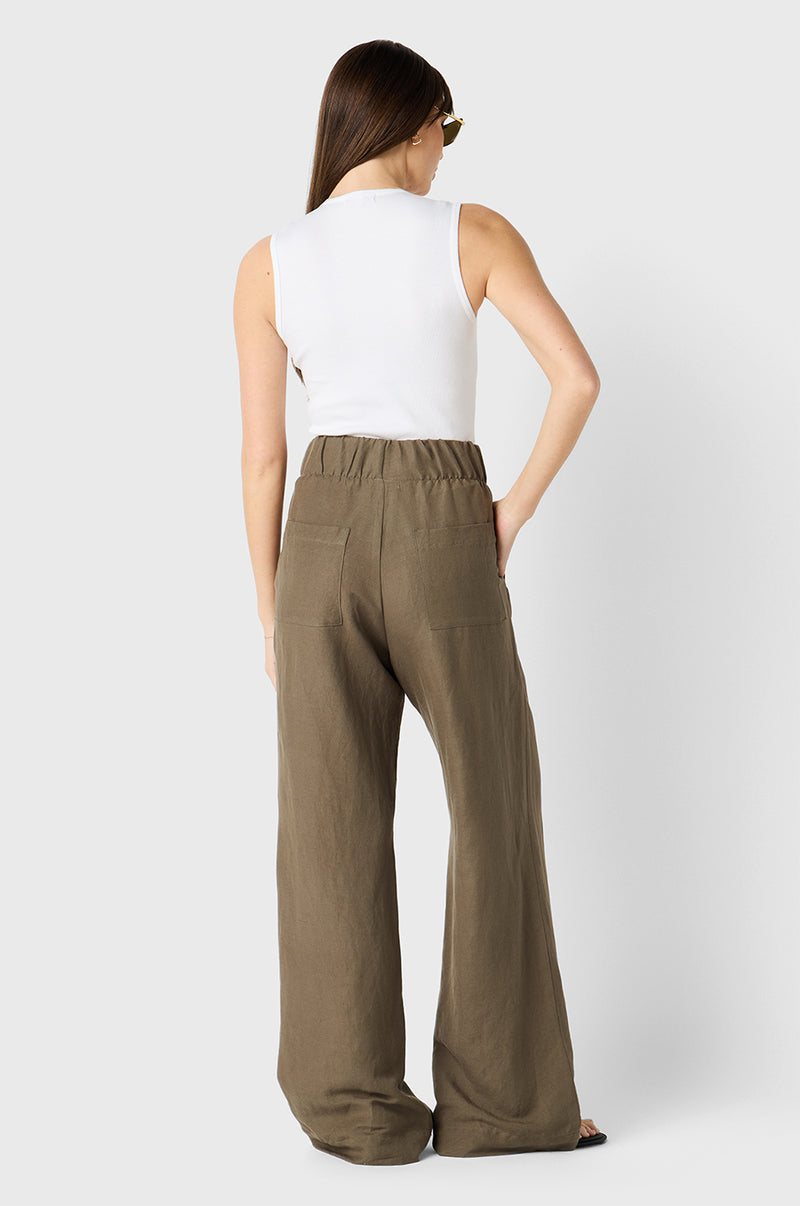 Brunette Model wearing the lady & the sailor Pleated Trouser in Moss