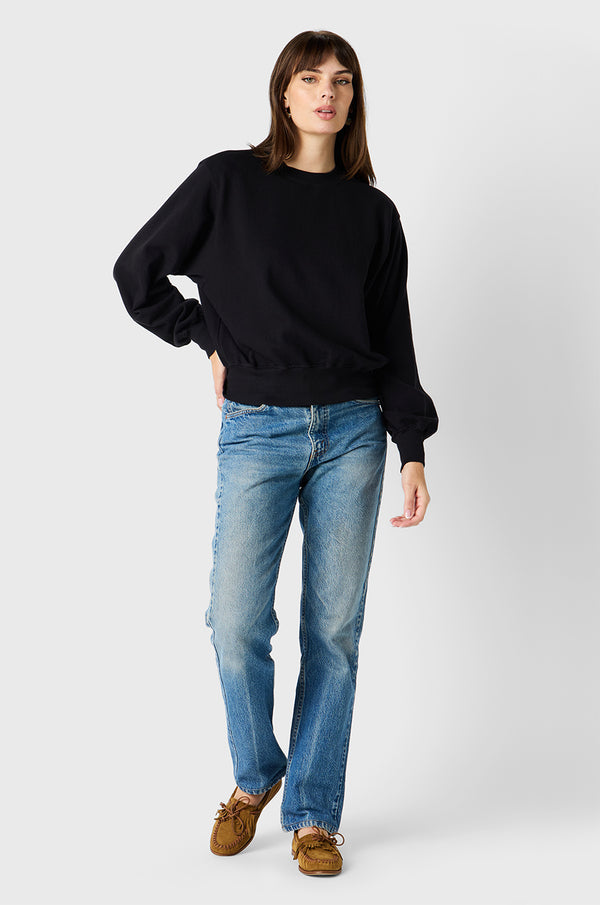 Brunette model wearing the lady & the sailor the Relaxed Sweatshirt in Black Organic Cotton.