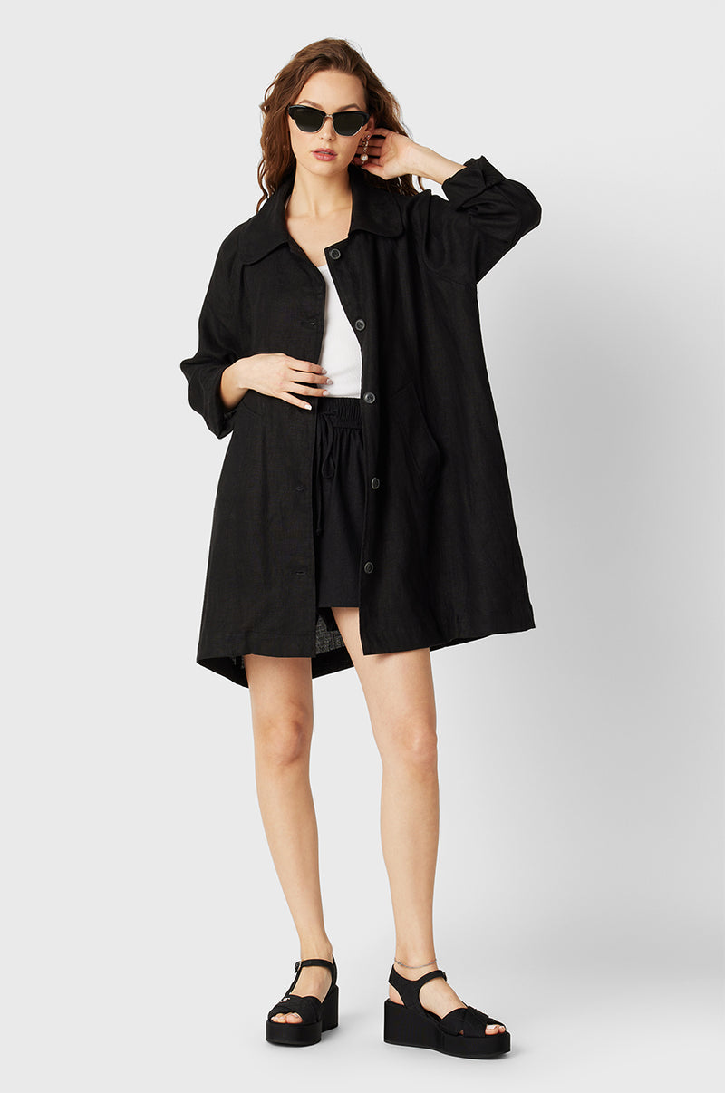 Brunette Model wearing the lady & the sailor Swing Coat in Black Linen.