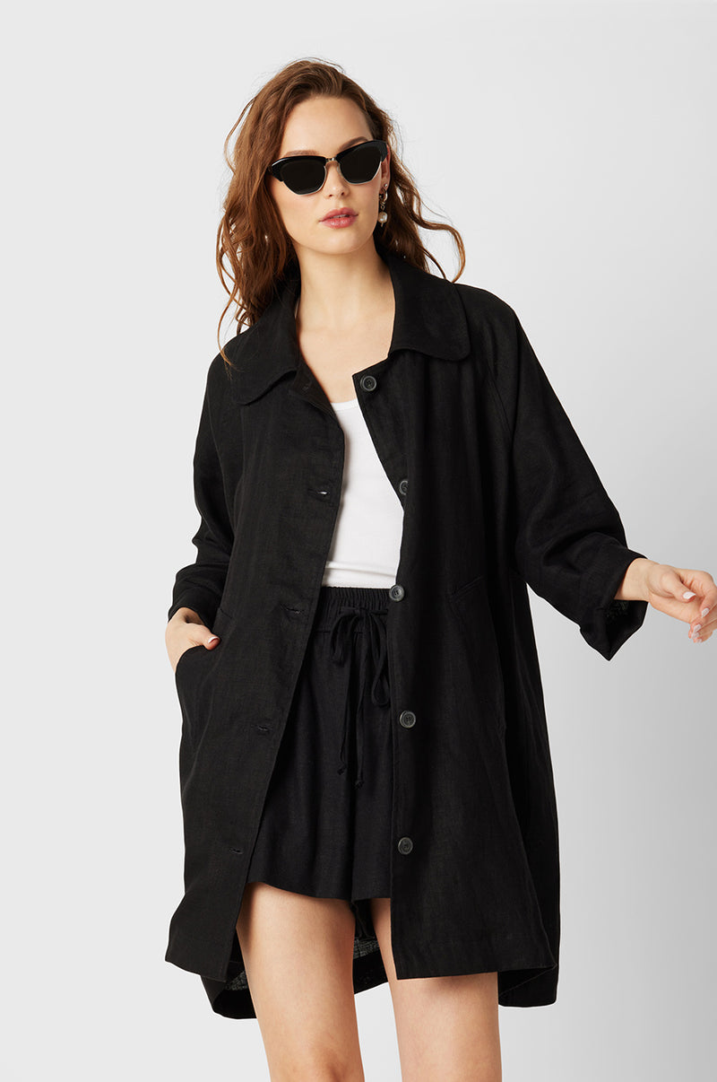 Brunette Model wearing the lady & the sailor Swing Coat in Black Linen.