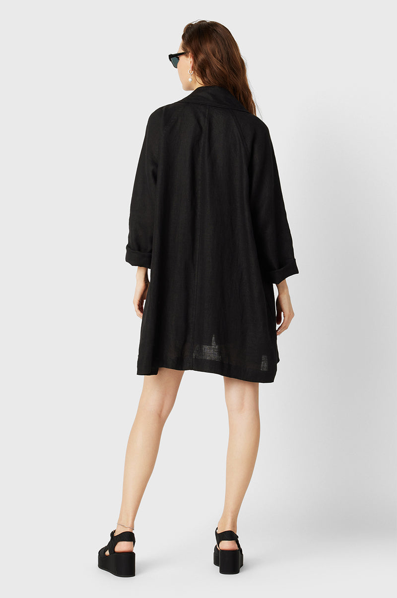 Brunette Model wearing the lady & the sailor Swing Coat in Black Linen.