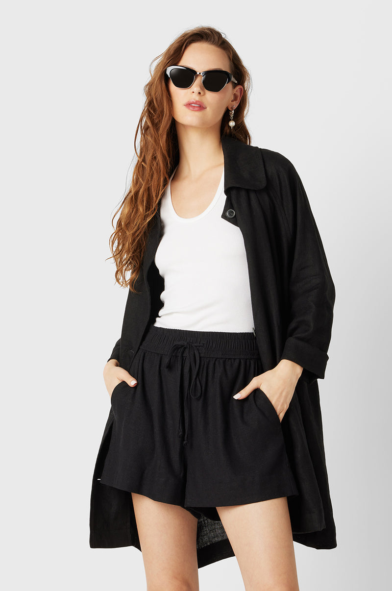 Brunette Model wearing the lady & the sailor Swing Coat in Black Linen.