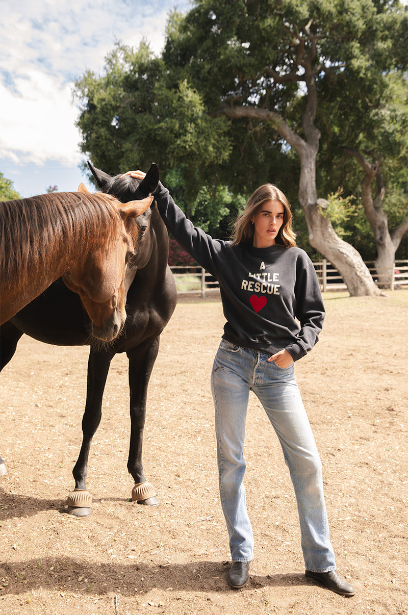 Brunette model wearing the lady & the sailor A little Rescue Sweatshirt in Vintage Black.