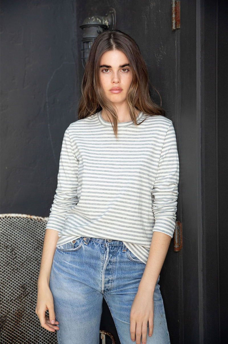 Brunette model the lady & the sailor Long Sleeve Boy Tee in Grey/Natural Stripe.