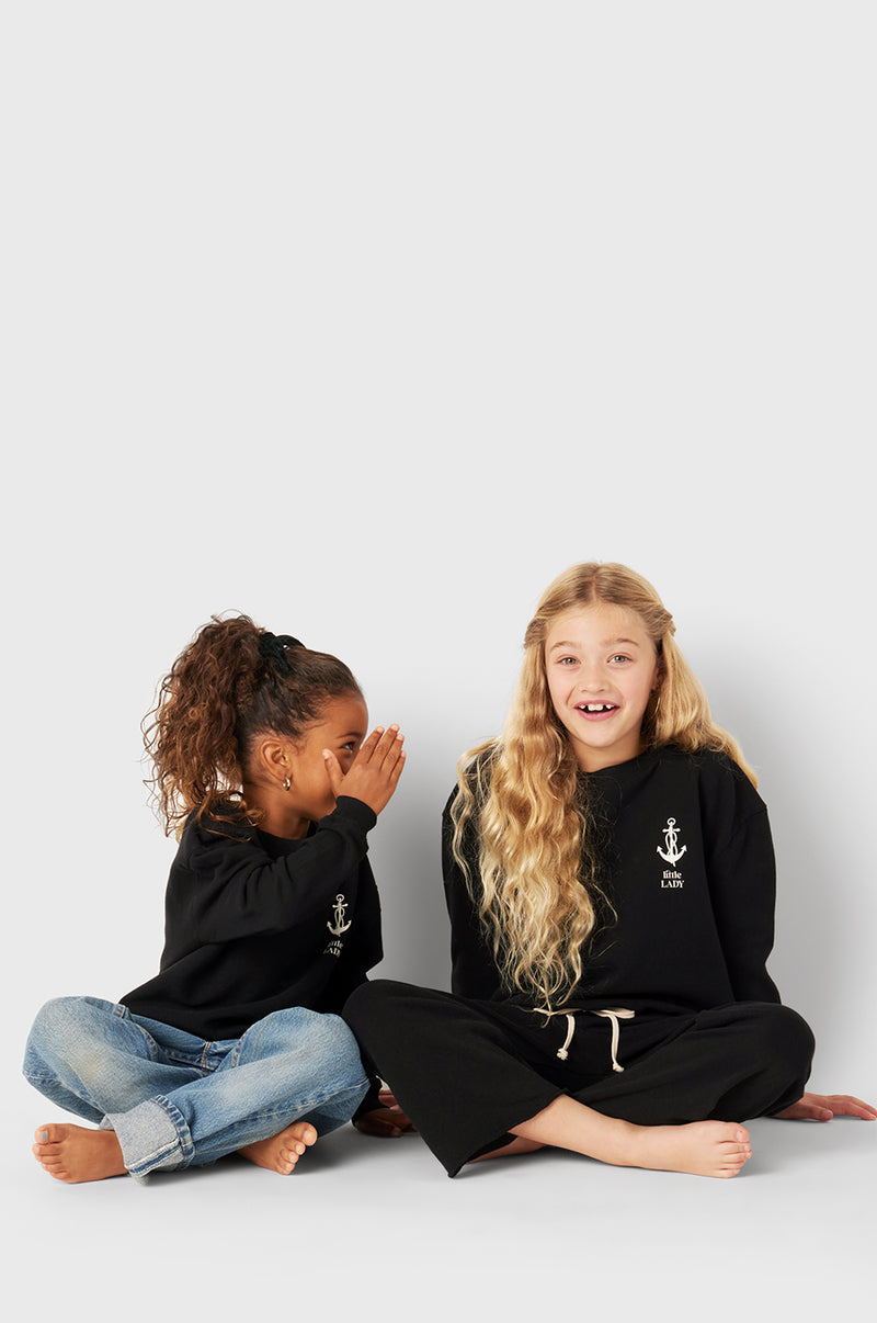 Model wearing Little Lady Varsity Crewneck in Black Organic Cotton little lady & petit sailor