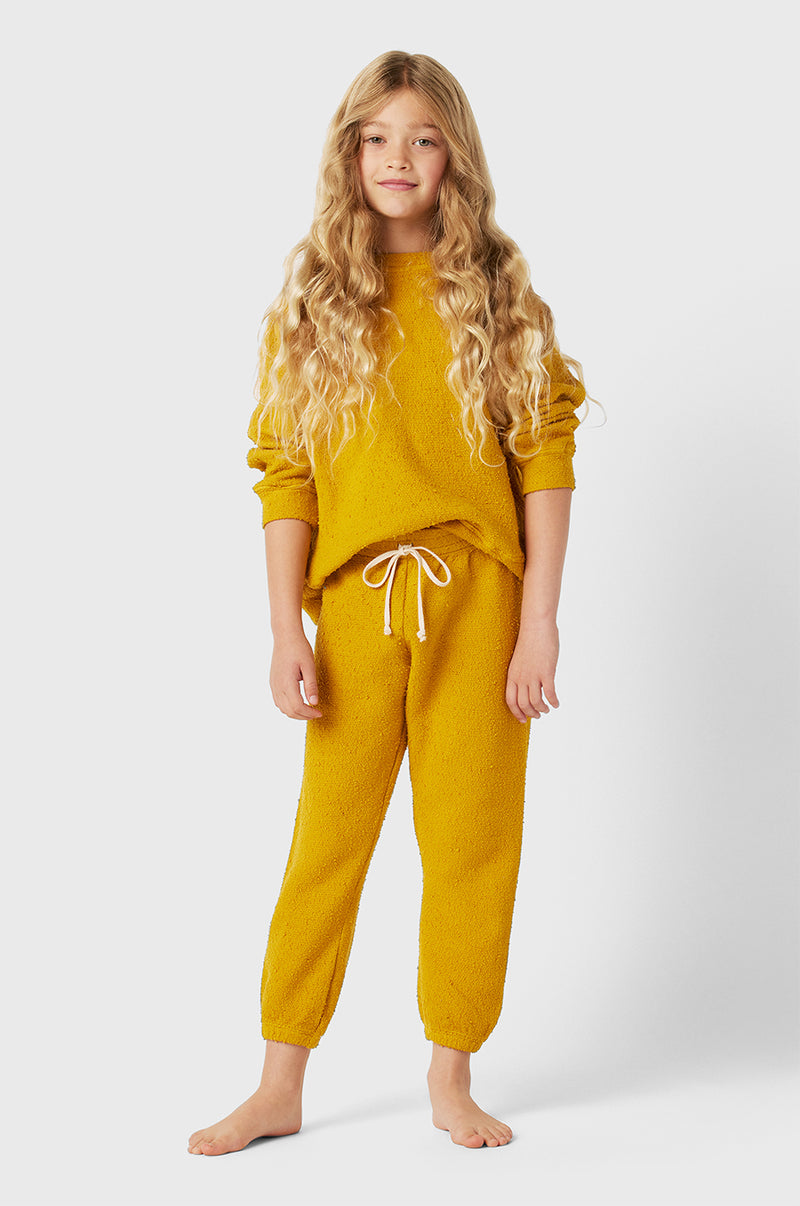 Model wearing Kids Vintage Sweatpant in Marigold Bouclé Kids yellow sweatshirt little lady & petit sailor