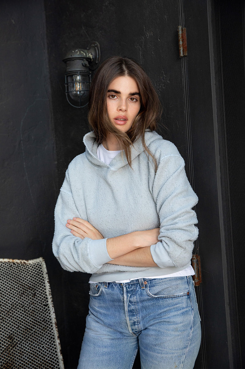 Brunette model wearing the lady and the sailor Hoodie in Seafoam Boucle.