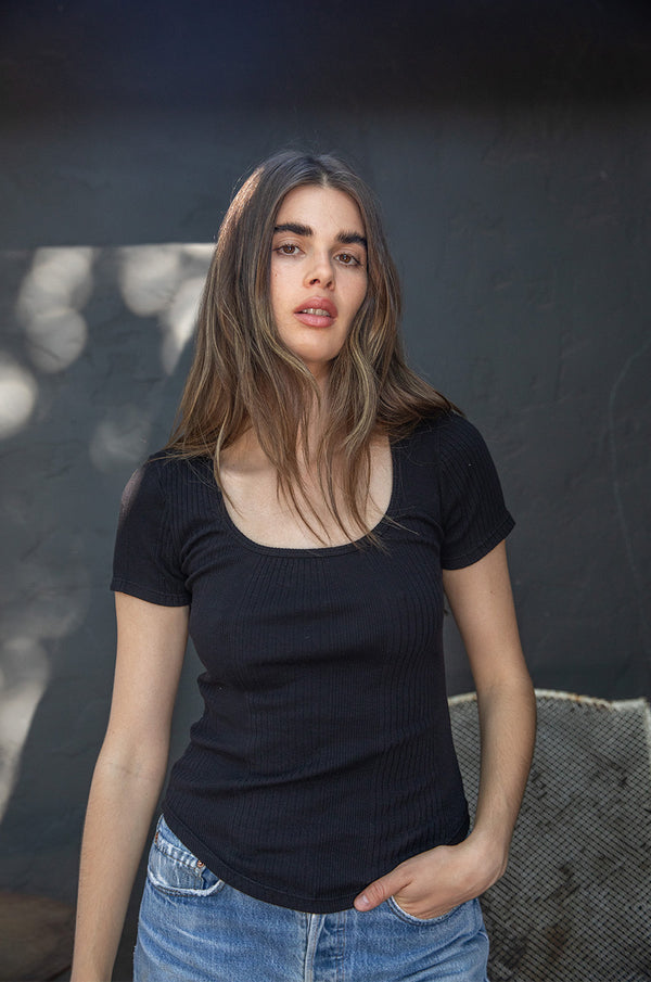Brunette model wearing the lady & the sailor Short Sleeve Scoopneck Tee in Black Variated Rib.