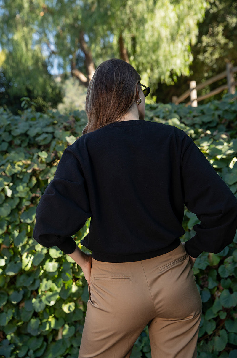 Brunette model wearing the lady & the sailor the Relaxed Sweatshirt in Black Organic Cotton.