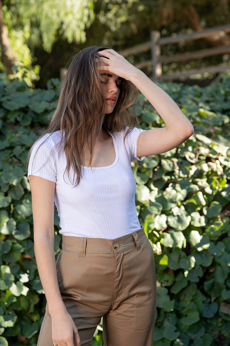 Brunette model wearing the lady & the sailor Short Sleeve Scoopneck Tee in White Variated Rib.