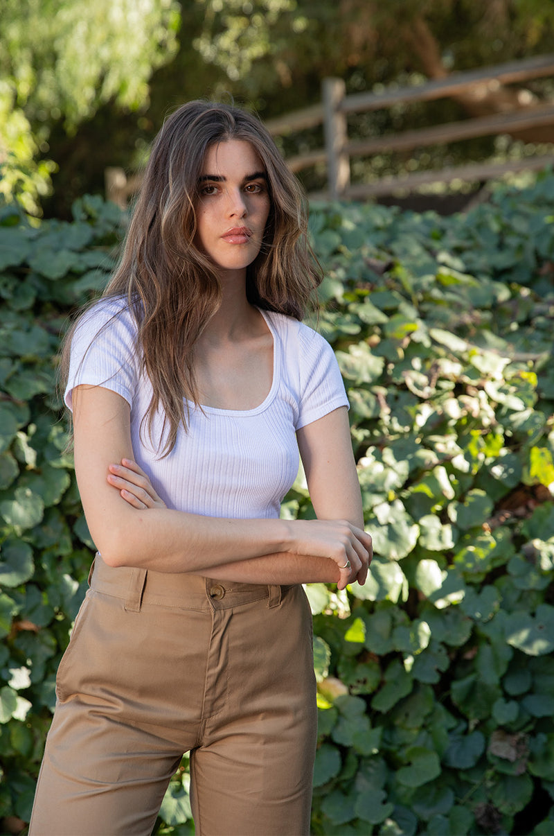 Brunette model wearing the lady & the sailor Short Sleeve Scoopneck Tee in White Variated Rib.