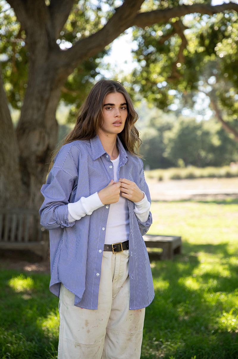 Brunette model wearing the lady & the sailor Long Sleeve Crewneck Tee in White Thermal. 