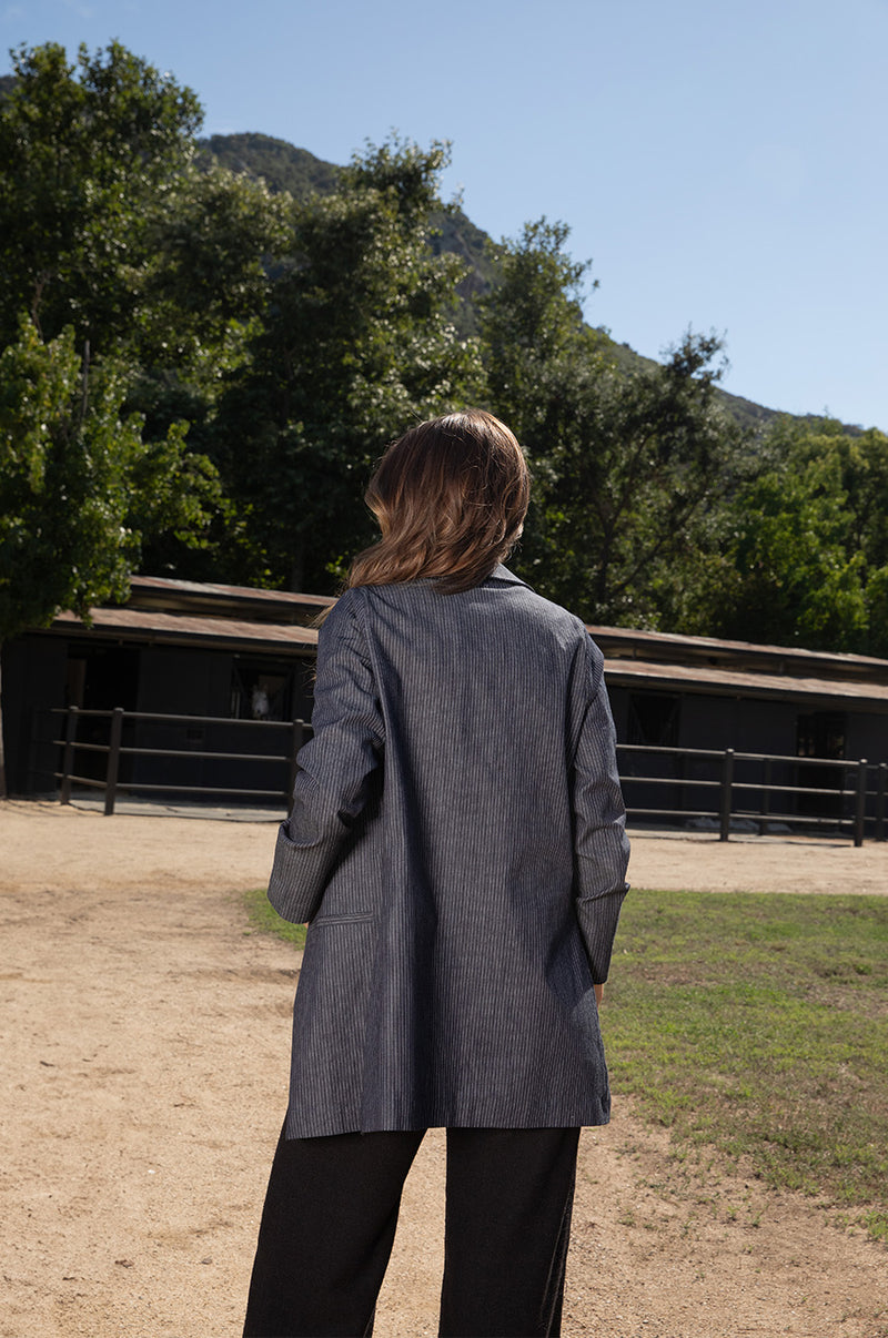 Brunette model wearing the lady & the sailor the Relaxed Blazer in Dark Denim Stripe.