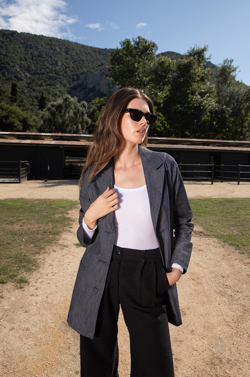 Brunette model wearing the lady & the sailor the Relaxed Blazer in Dark Denim Stripe.