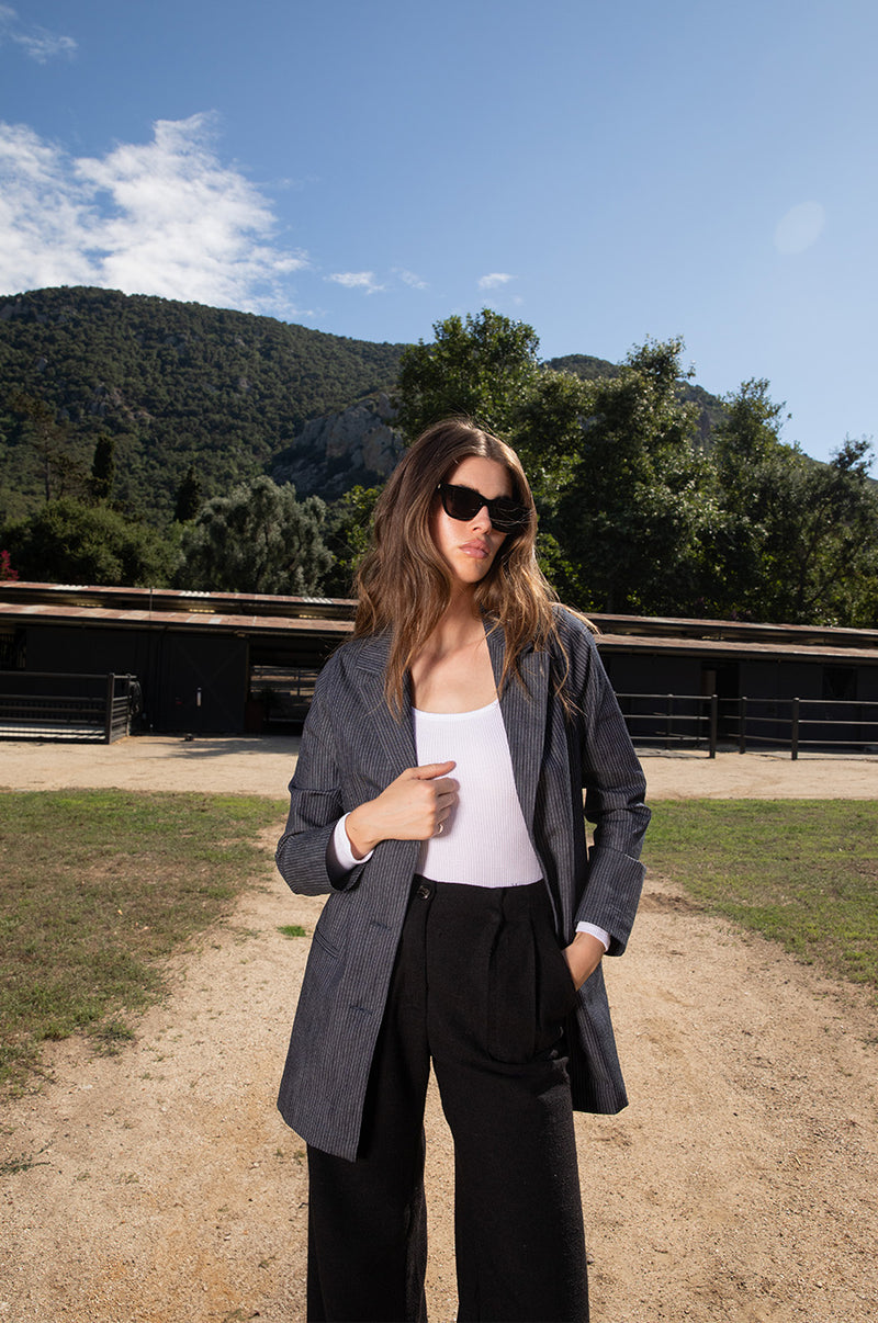 Brunette model wearing the lady & the sailor the Relaxed Blazer in Dark Denim Stripe.