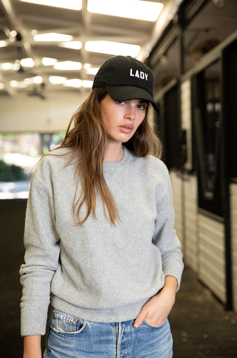 Brunette model wearing the lady & the sailor Varsity Crewneck in Heather Grey Sherpa.