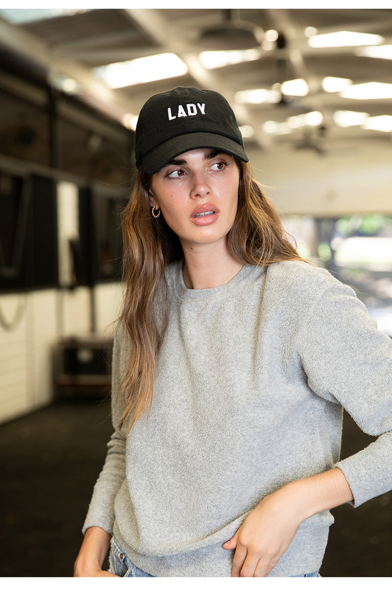 Brunette model wearing the lady & the sailor Varsity Crewneck in Heather Grey Sherpa.