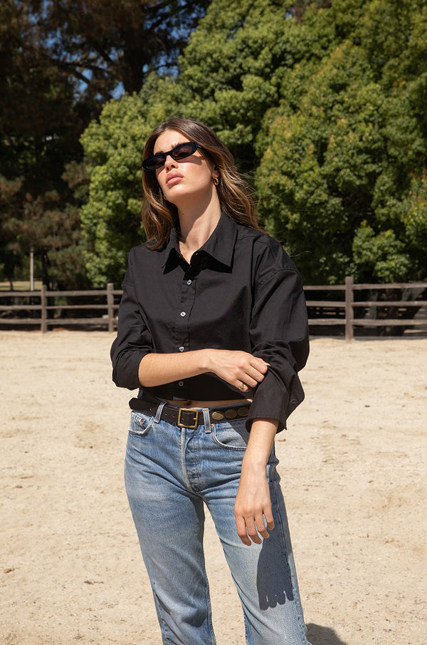 Brunette model wearing the lady & the sailor Cropped Button Up in Black Poplin.