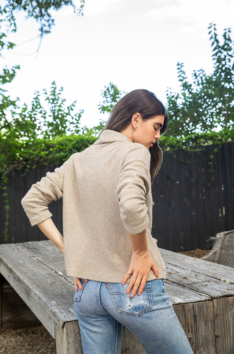 Brunette model wearing the lady and the sailor Pocket Cardi in Stone Bouclé.