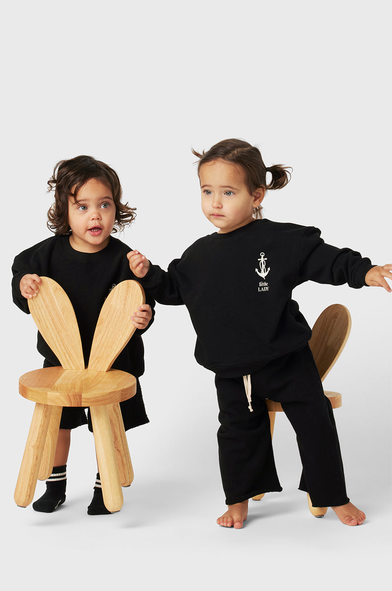 Model wearing Little Lady Varsity Crewneck in Black Organic Cotton little lady & petit sailor