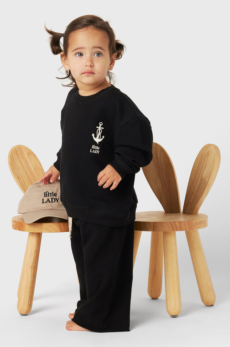 Model wearing Little Lady Varsity Crewneck in Black Organic Cotton little lady & petit sailor