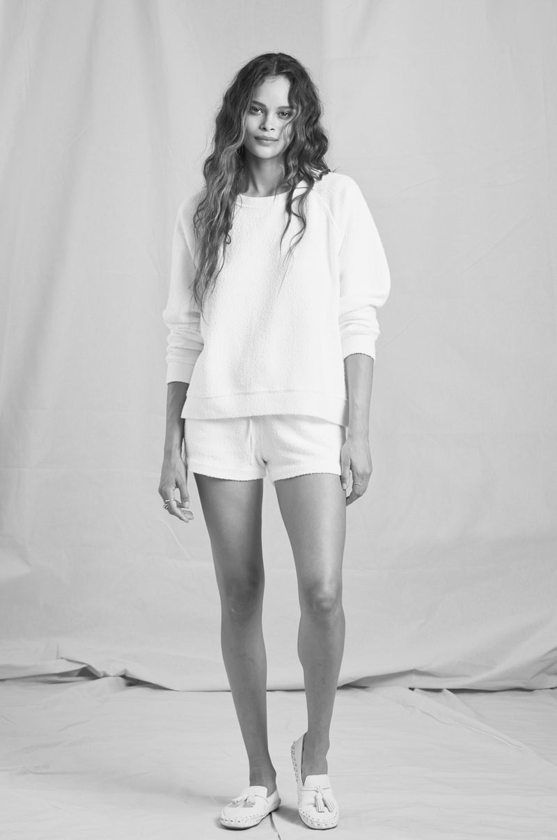 Brunette Model wearing the lady & the sailor Brentwood Sweatshirt in White Bouclé.