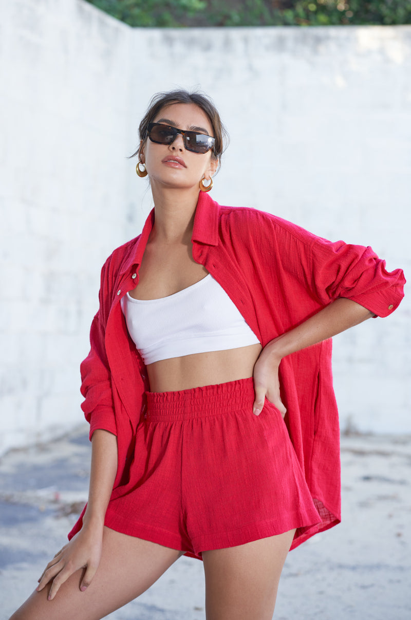 Brunette Model wearing the lady & the sailor Smock Band Shorts in Red Gauze.