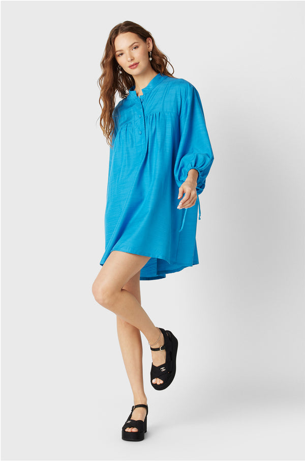 Brunette Model wearing the lady & the sailor Billow Sleeve Mini Dress in Turquoise.