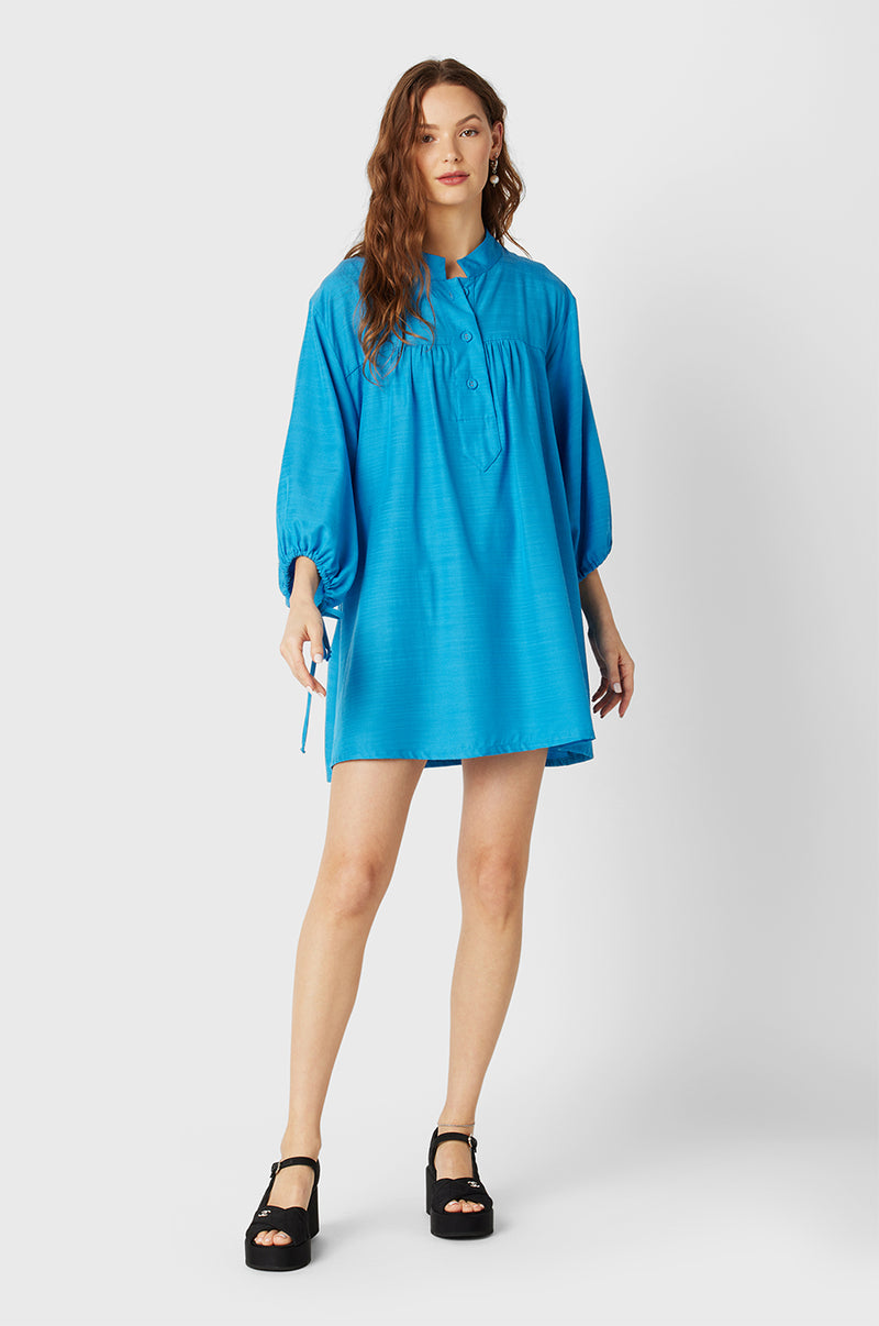 Brunette Model wearing the lady & the sailor Billow Sleeve Mini Dress in Turquoise.
