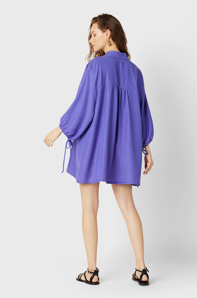 Brunette Model wearing the lady & the sailor Billow Sleeve Mini Dress in Purple.