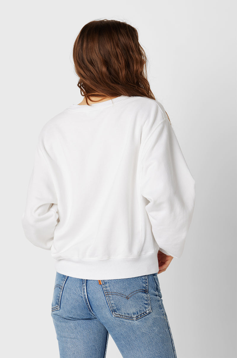 Brunette Model wearing the lady & the sailor The Kristin Sweatshirt in White Fleece.
