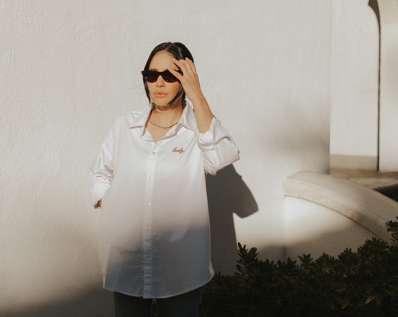 Brunette Model wearing the lady & the sailor Lady Button Up in White Cotton Poplin/Ruby.