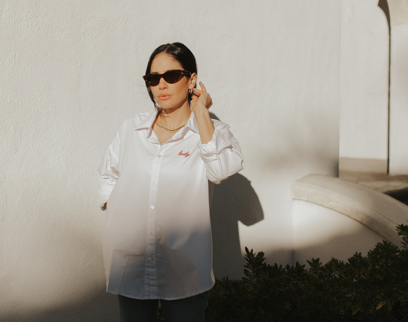 Brunette Model wearing the lady & the sailor Lady Button Up in White Cotton Poplin/Ruby.