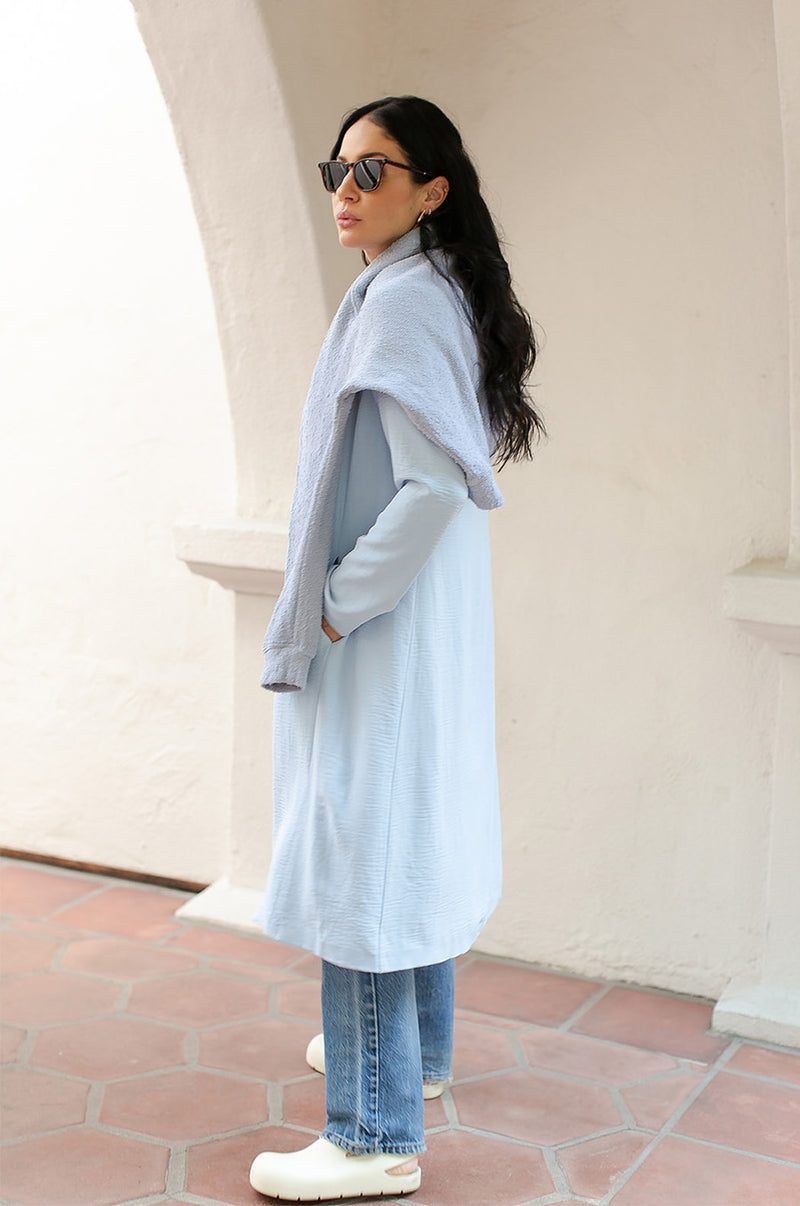 Brunette Model wearing the lady & the sailor Midi Duster Coat in Glacier Air Flow.