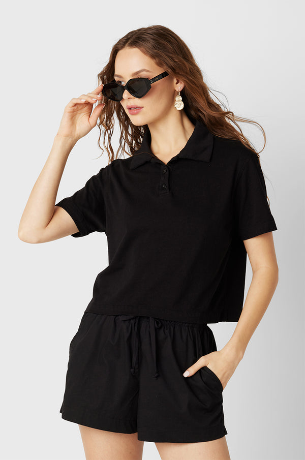 Brunette Model wearing the lady & the sailor the Polo T-Shirt in Black Vintage Cotton.