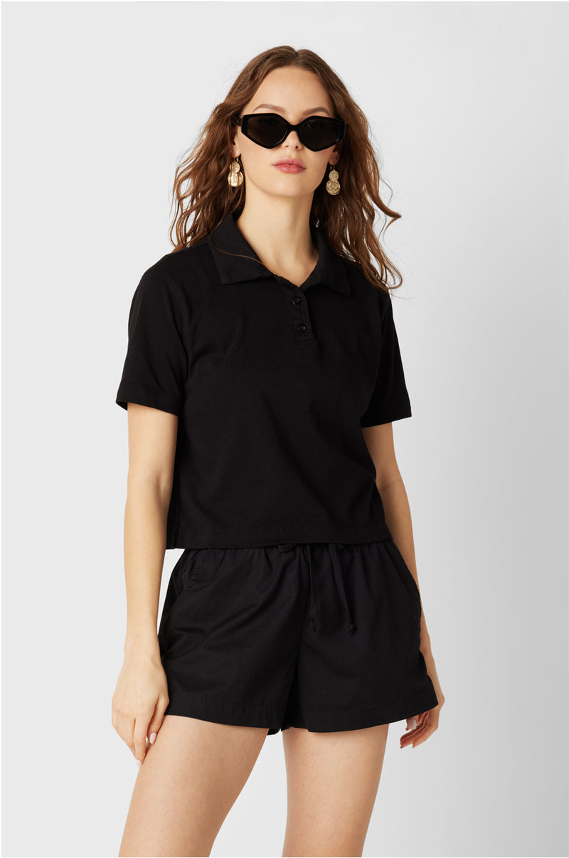 Brunette Model wearing the lady & the sailor the Polo T-Shirt in Black Vintage Cotton.